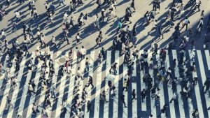 Fotografía de gente cruzando una calle por una senda peatonal